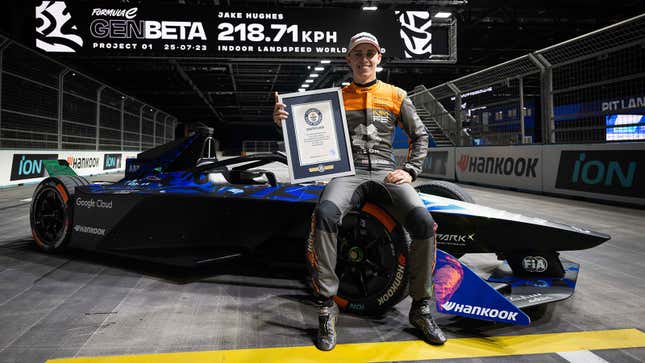 A photo of Formula E driver Jake Hughes sat on a race car. 